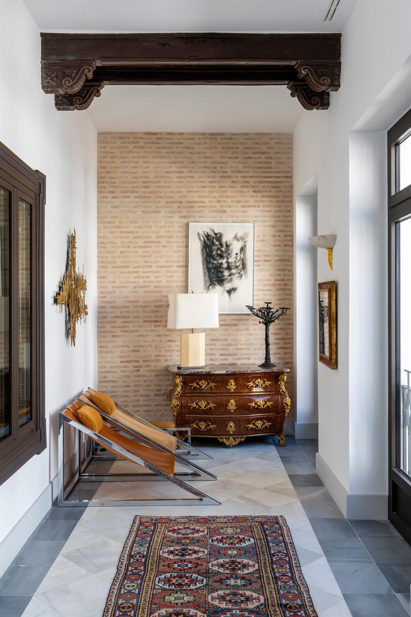 Pasillo interior con cómoda antigua y alfombra en el Hotel La Casa del Limonero