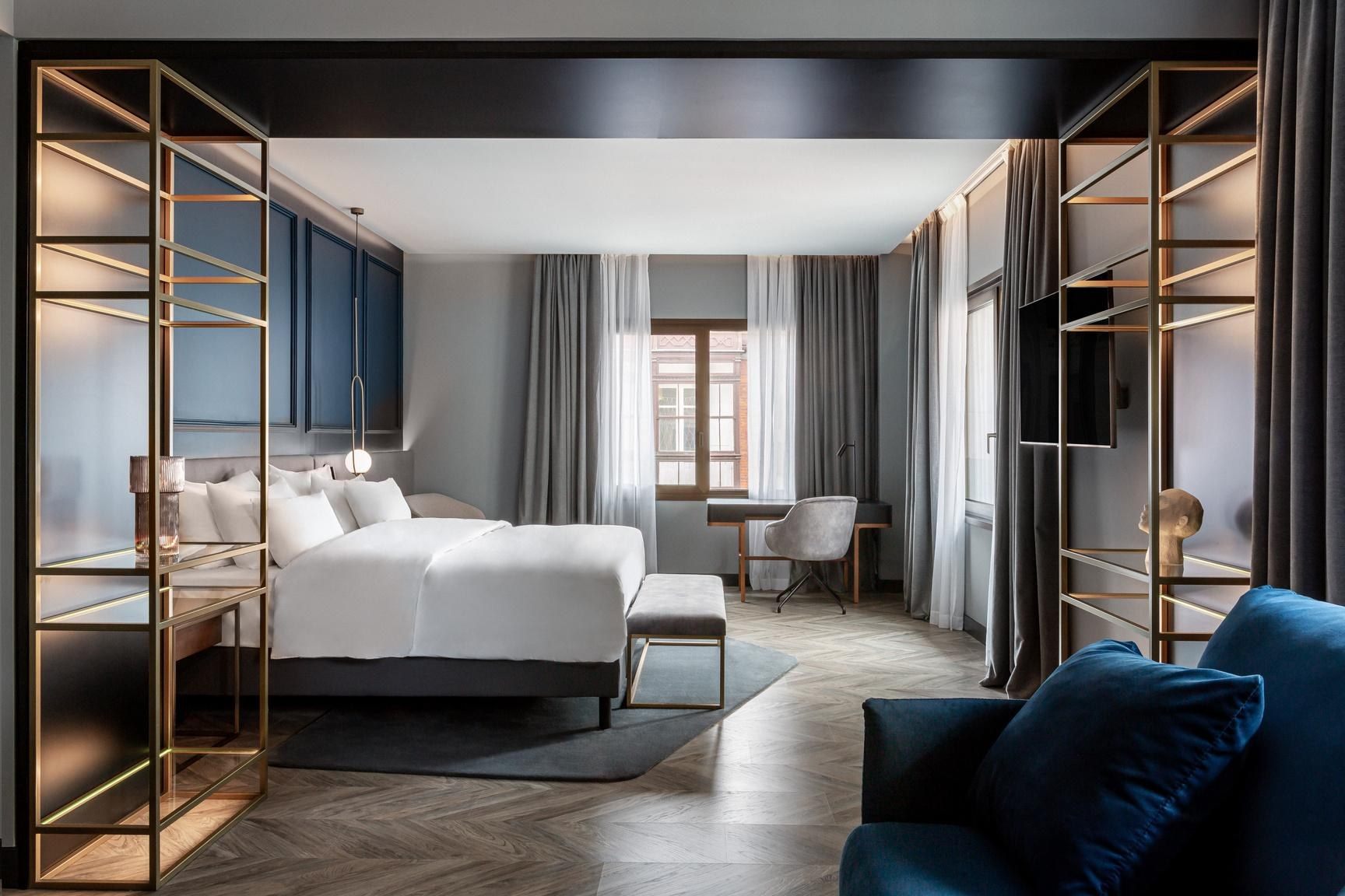 Habitación del Radisson Collection Bilbao con cama y sofá azul